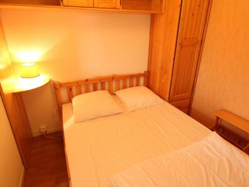 une petite chambre avec un lit blanc et une lampe dans l'établissement Proche Thermes - T2 Cabine avec Balcon, Parking et Wifi - Animaux admis - FR-1-313-170, à Luchon