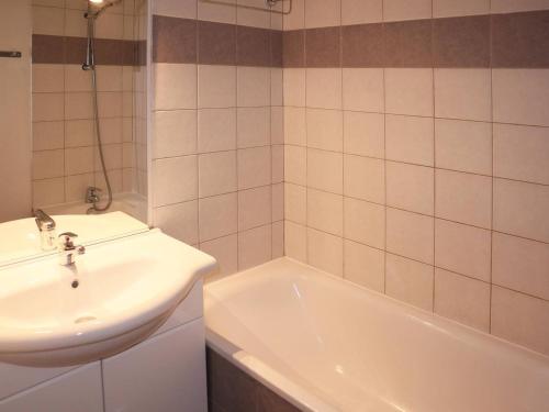 une salle de bain avec un lavabo et une baignoire et un lavabo dans l'établissement Appartement 4 pers avec piscine, jacuzzi et balcon, proche des pistes - Les Orres - FR-1-322-421, aux Orres