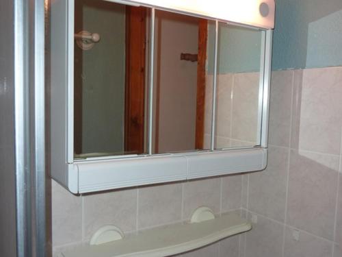 - un miroir au-dessus d'un lavabo dans la salle de bains dans l'établissement Charmant T2 au pied des pistes, terrasse sud, proche commerces et télécabine - FR-1-573-35, à Saint-Jean-dʼAulps