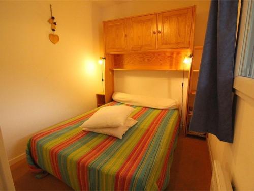 - une petite chambre avec un lit et une couverture colorée dans l'établissement Luchon: Appart 2 pièces cabine - Balcon, Parking - FR-1-313-166, à Luchon