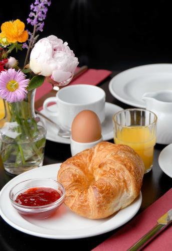 a plate with a croissant and eggs on a table at Hotel Deutsches Theater Stadtzentrum in Munich