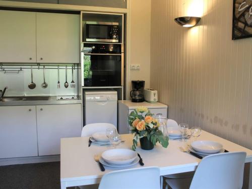 a kitchen with a table with plates and flowers on it at Studio 4 Pers à Vars - Emplacement Idéal Proche Pistes et Commerces - FR-1-330B-179 in Vars