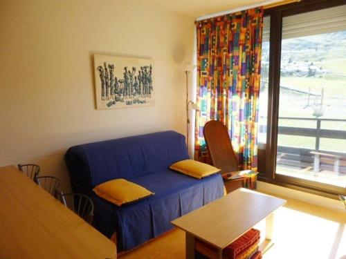 a living room with a blue couch and a table at Appartement Arette, 2 pièces, 6 personnes - FR-1-602-60 in Arette