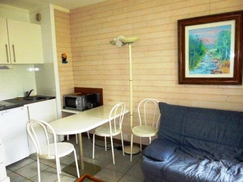 une cuisine avec une table, des chaises et un canapé dans l'établissement Studio 5 pers. au pied des pistes - Accès direct, parking gratuit, casier à skis, service fondue - FR-1-602-16, à Arette