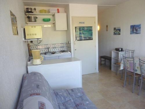 a kitchen with a counter and a table and chairs at Studio familial 6 pers. accès pistes, balcon, parking gratuit, casier à skis - FR-1-602-24 in Arette