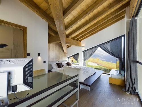a bedroom with a bed and a desk with a television at Chalet Montvalezan-La Rosière, 6 pièces, 10 personnes - FR-1-398-633 in Montvalezan