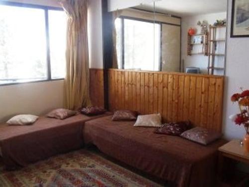 deux lits dans une chambre avec deux fenêtres dans l'établissement Studio cosy 4 personnes au pied des pistes avec parking et casier à skis - FR-1-602-49, à Arette