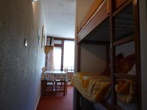 a bedroom with a bunk bed and a table in a room at Studio Arette, 1 pièce, 4 personnes - FR-1-602-69 in Arette
