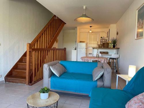 - un salon avec un canapé bleu et un escalier dans l'établissement Maison 2 chambres avec garage, proche plage des Elmes - FR-1-225C-88, à Banyuls-sur-Mer