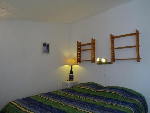 une chambre avec un lit et une lampe sur une table dans l'établissement Appartement familial 6 pers avec balcon et accès direct aux pistes - FR-1-602-79, à Arette