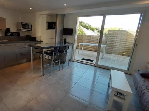 une cuisine et un salon avec une table et un canapé dans l'établissement Charmant T2 proche océan avec terrasse, wifi et parking privé - Vieux-Boucau, 4/5 pers. - FR-1-379-132, à Vieux-Boucau-les-Bains