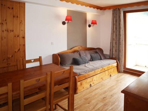 a bedroom with a wooden bed and a table at Appartement Les Orres, 2 pièces, 6 personnes - FR-1-322-438 in Les Orres