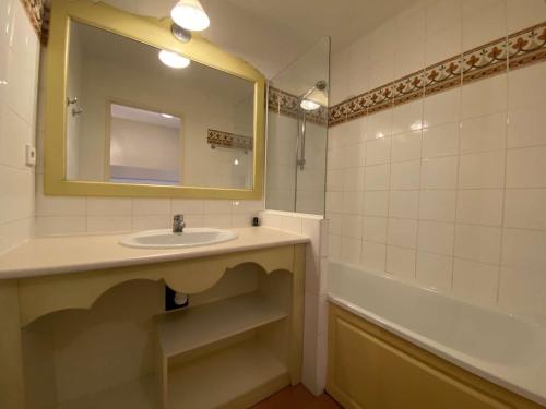 une salle de bain avec un lavabo, une baignoire et un miroir dans l'établissement Studio familial 4 pers. avec piscine, tennis et parking – Les Issambres - FR-1-226-455, à Saint-Peïre-sur-Mer