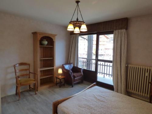 1 dormitorio con 1 cama, 1 silla y 1 ventana en Maison Le Grand-Bornand, 3 pièces, 6 personnes - FR-1-458-96, en Le Grand-Bornand