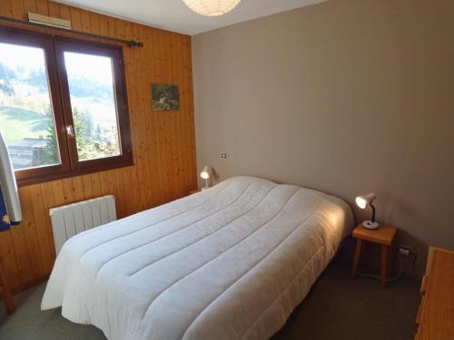 een slaapkamer met een wit bed en een raam bij Appartement Le Grand-Bornand, 3 pièces, 6 personnes - FR-1-458-93 in Le Grand-Bornand