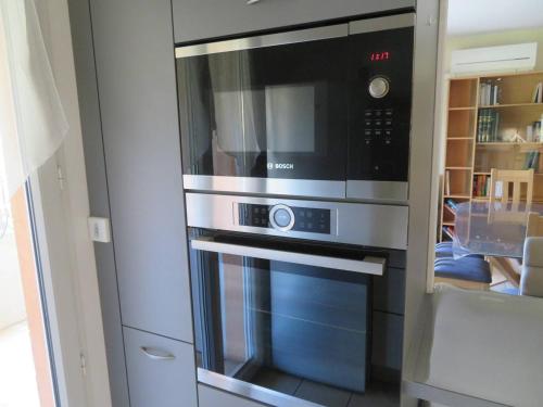 d'une cuisine équipée d'un four micro-ondes. dans l'établissement T3 68m², 4*, climatisé avec loggia, proche mer et commerces – Bormes-les-Mimosas - FR-1-610-14, à Bormes-les-Mimosas