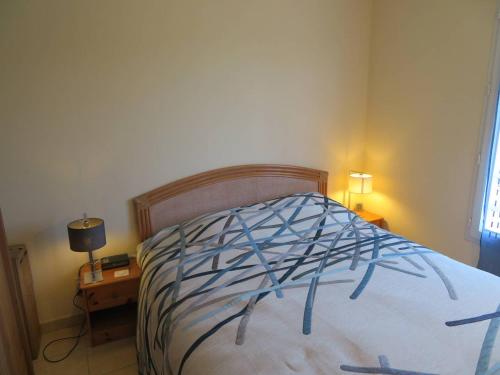 ein Schlafzimmer mit einem Bett mit einer blau-weißen Bettdecke in der Unterkunft T3 68m², 4*, climatisé avec loggia, proche mer et commerces – Bormes-les-Mimosas - FR-1-610-14 in Bormes-les-Mimosas