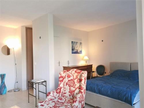 une chambre avec un lit, une chaise et un bureau dans l'établissement Appartement climatisé avec terrasse, piscine et parking privé, proche plages et commerces - FR-1-609-60, à Mandelieu-la-Napoule