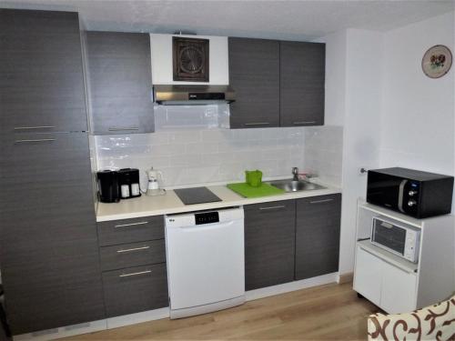 une petite cuisine avec un évier et un micro-ondes dans l'établissement Duplex lumineux au calme, 6 pers, WiFi, balcons, proche pistes - FR-1-292-174, à Isola