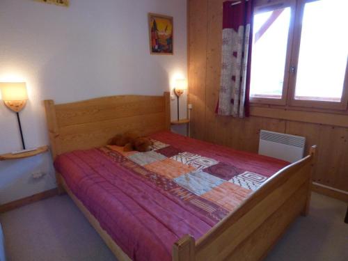 une chambre avec un lit avec un ours en peluche dessus dans l'établissement Charmant appartement au pied des pistes - 41m² - 6 pers - Ambiance Montagne - Garage fermé inclus - FR-1-458-109, au Grand-Bornand