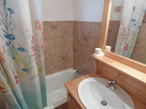 une salle de bain avec un lavabo et un rideau de douche dans l'établissement Lumineux studio savoyard avec balcon exposé SUD - FR-1-458-114, au Grand-Bornand