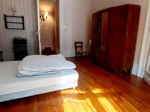 Schlafzimmer mit einem weißen Bett und Holzboden in der Unterkunft Appartement Cauterets, 4 pièces, 8 personnes - FR-1-234-258 in Cauterets