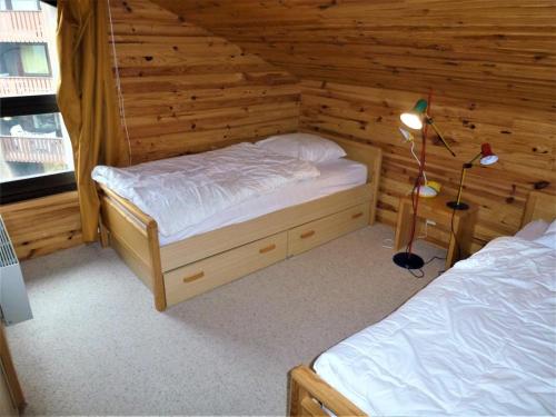 une chambre avec deux lits dans une cabane en rondins dans l'établissement Duplex lumineux au calme, 6 pers, WiFi, balcons, proche pistes - FR-1-292-174, à Isola