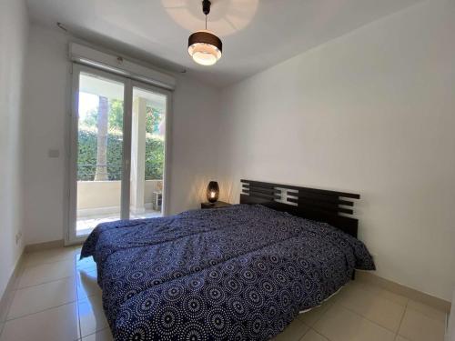 une chambre avec un lit et une grande fenêtre dans l'établissement Appartement 3P avec Terrasse et Garage, à 10min des Plages de Juan-les-Pins - FR-1-252-171, à Antibes