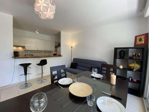 Il comprend un salon avec une table à manger et une cuisine. dans l'établissement Appartement 3P avec Terrasse et Garage, à 10min des Plages de Juan-les-Pins - FR-1-252-171, à Antibes