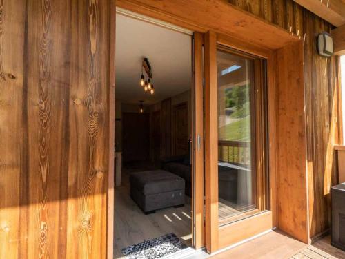 una puerta corredera de cristal abierta a una habitación con sofá en Appartement Les Avanchers-Valmorel, 2 pièces, 4 personnes - FR-1-291-867, en Valmorel