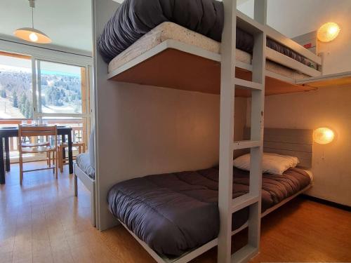 - une chambre avec des lits superposés, une table et une salle à manger dans l'établissement Studio cosy proche pistes avec Wifi, parking et animaux admis - FR-1-525-190, à Saint-Étienne-en-Dévoluy