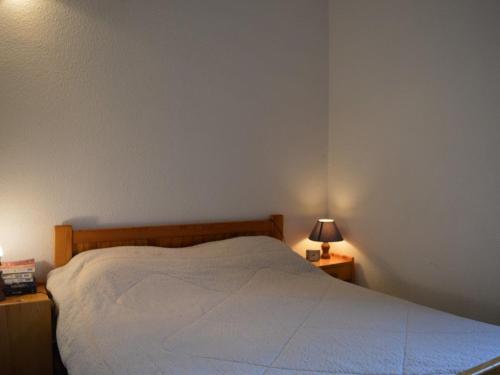 - une chambre avec un lit blanc et 2 tables de nuit avec des lampes dans l'établissement Maison climatisée 2 pièces/mez, 5 couchages, proche port et plage, parking, véranda, terrasse, animaux OK - FR-1-225D-110, à Saint-Cyprien