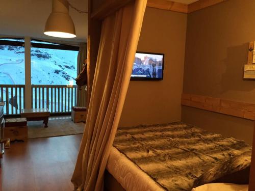 a bedroom with a canopy bed with a tv on the wall at Studio Val Thorens, 2 pièces, 3 personnes - FR-1-637-2 in Val Thorens