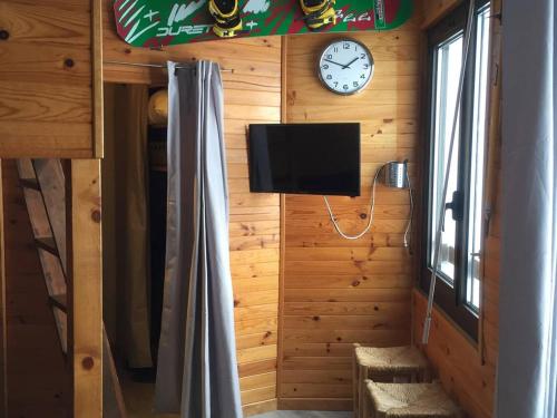 Cette chambre dispose d'une télévision et d'une horloge murale. dans l'établissement Studio pour 4 personnes avec ascenseur, parking gratuit et accès direct aux pistes - FR-1-602-82, à Arette