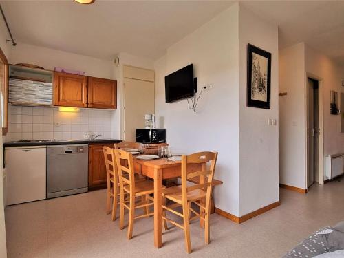 Il comprend une cuisine avec une table et des chaises en bois. dans l'établissement Appartement Cosy 6 Pers, Proche Pistes, Parking, Animaux Bienvenus - FR-1-525-195, à Saint-Étienne-en-Dévoluy