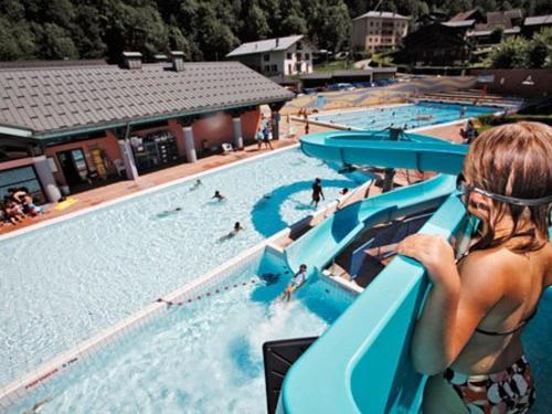 a woman riding a slide in a swimming pool at Appartement confortable et lumineux, 66m², 2 chambres, 5 personnes, Beaufort – Wifi inclus, proche services - FR-1-342-228 in Beaufort