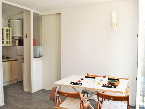 une salle à manger avec une table et des chaises blanches dans l'établissement Appartement Climat. 4 pers. avec Parking Privatif au Lavandou, Proche Centre et Plage - FR-1-251-390, au Lavandou