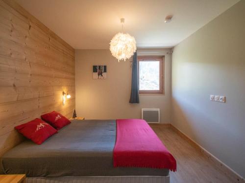 ein Schlafzimmer mit einem großen Bett mit einer roten Decke in der Unterkunft Charmette 2 pièces avec parking, terrasse et casier à skis - FR-1-291-860 in Valmorel
