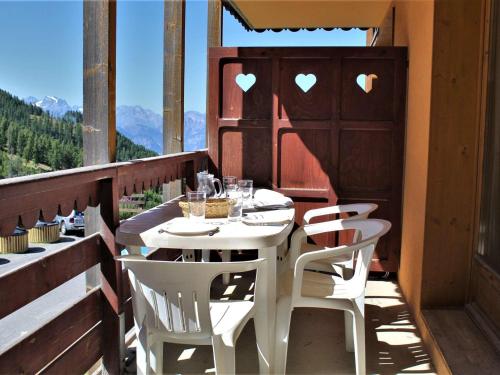 une table blanche et des chaises sur un balcon dans l'établissement Appartement cosy 2 pièces, bien équipé, accès facile aux pistes - 6 couchages, animaux admis - FR-1-330-511, à Risoul