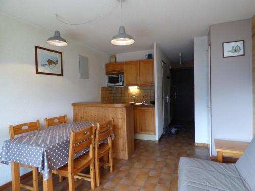 une cuisine et une salle à manger avec une table et des chaises dans l'établissement Studio cosy avec balcon, arrêt navette à 50m - FR-1-458-100, au Grand-Bornand