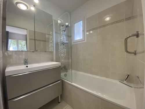 une salle de bain avec une baignoire, un lavabo et une douche dans l'établissement Sainte-Maxime: Appart 3P climatisé avec piscine, parking privé et jardin calme - FR-1-226-471, à Sainte-Maxime