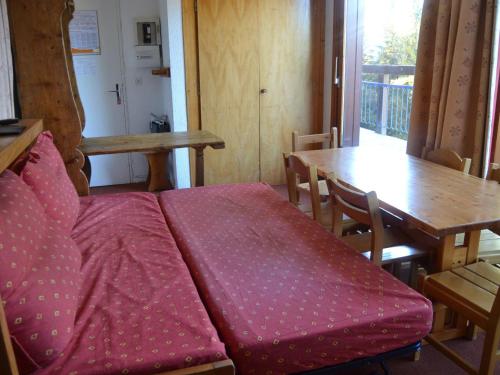 - un canapé rouge dans une pièce avec une table dans l'établissement Appartement 3P, 7 pers, proche pistes et commerces, cœur du village, Arc 1800 - FR-1-411-698, à Bourg-Saint-Maurice