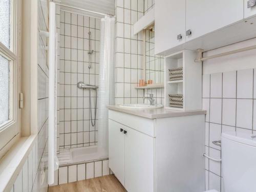 une salle de bain blanche avec un lavabo et une douche dans l'établissement Appartement Centre Cauterets 4/6 pers avec Balcon, Cuisine Équipée et Local à Skis - FR-1-401-226, à Cauterets