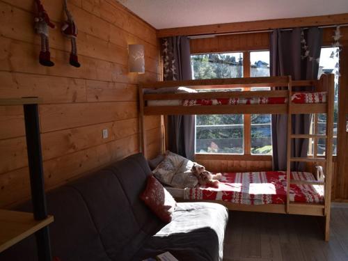 a bedroom with two bunk beds and a couch at Studio Montgenèvre, 1 pièce, 4 personnes - FR-1-266-166 in Montgenèvre