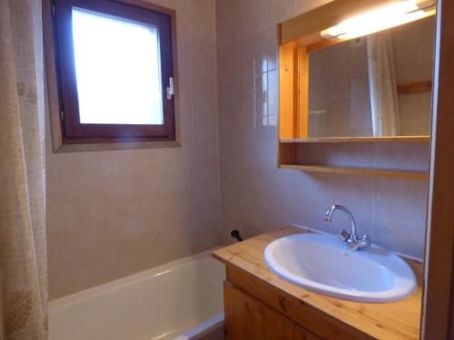 a bathroom with a sink and a window and a tub at Appartement Le Grand-Bornand, 3 pièces, 6 personnes - FR-1-458-118 in Le Grand-Bornand