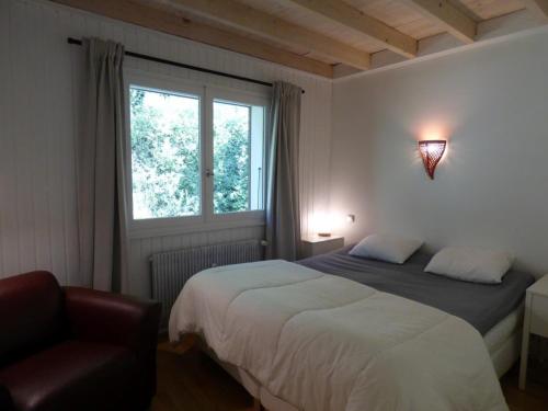 - une chambre avec un lit, une chaise et une fenêtre dans l'établissement Appartement Le Grand-Bornand, 3 pièces, 6 personnes - FR-1-458-144, au Grand-Bornand