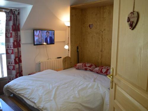 une chambre avec un lit et une télévision au mur dans l'établissement Studio confortable avec équipements modernes à Montgenèvre, animaux acceptés - FR-1-266-170, à Montgenèvre