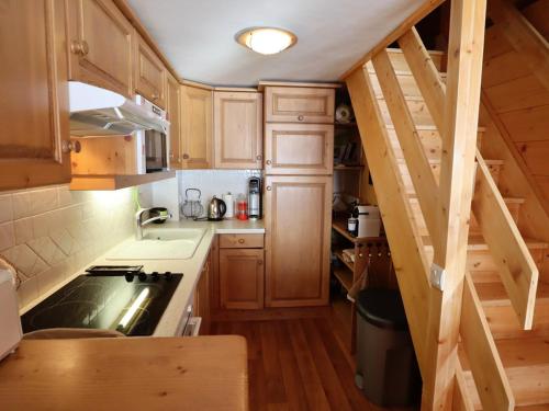 une petite cuisine avec des placards en bois et un escalier dans l'établissement Superbe duplex au pied des pistes avec garage et terrasse - FR-1-342-231, à Beaufort