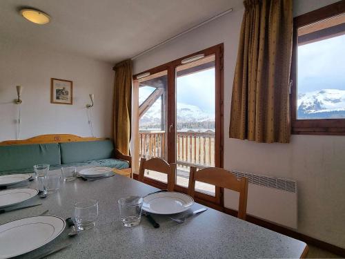 d'une salle à manger avec une table et une vue sur les montagnes. dans l'établissement Appartement cosy 2 pièces avec balcon, proche télésiège - 6 couchages - Dévoluy - FR-1-525-197, à Saint-Étienne-en-Dévoluy