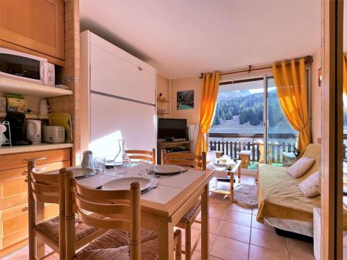 une cuisine et un salon avec une table et une salle à manger dans l'établissement Studio au pied des pistes pour 4 avec Wifi, parking et animaux admis - FR-1-525-181, à Saint-Étienne-en-Dévoluy